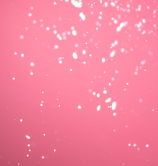 Splashing milk on a pink background.