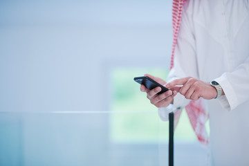 young arabian businessman using smartphone at home