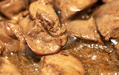 Chicken liver is fried in a pan.