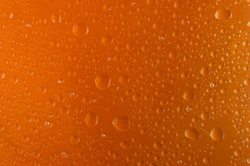background for design of water drop close up on an orange surface