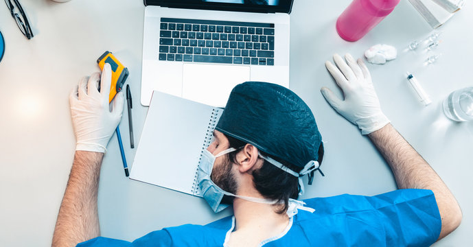 Medico o infermiere dorme in reparto dell'ospedale sul tavolo dopo un turno stancante in terapia intensiva a curare i malati di coronavirus.