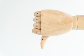 gesture thumb down, made by artificial wooden hand on white background, communication skills, sign that means dislike