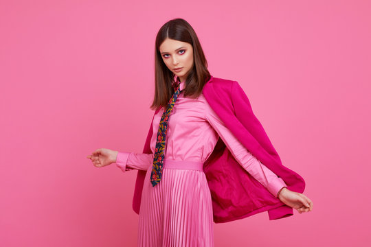 Fashion model in magenta jacket, pink skirt and shirt.