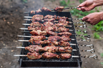 Man flips, cooks kebab on the grill, outdoors