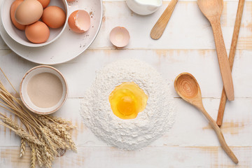 Ingredients for dough on white wooden background