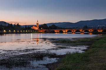 Bridge Ponte de Lima with church during sunset, river Lima, church and bridge illuminated, Portugal.