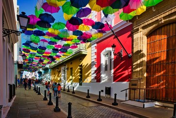 Shoppers stroll through historic Old San Juan. It is the oldest settlement within Puerto Rico and the historic colonial section of the city of San Juan. - obrazy, fototapety, plakaty