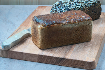 loaf of wheat bread and loaf of bread with seeds  on the kitchen table