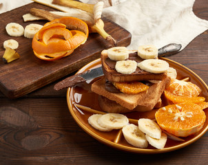 toasted sandwiches with chocolate paste and banana slices on a plate, morning breakfast