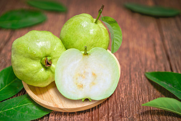 Guava fruit with leaf on a wooden background, Guava fruit on the brown wooden table.