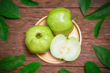 Guava fruit with leaf on a wooden background, Guava fruit on the brown wooden table.