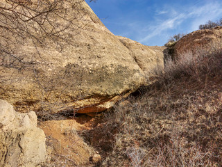 The rock erodes against the sky with clouds.
