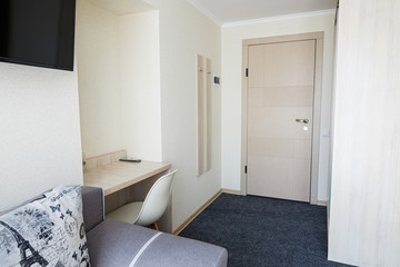 Bright lounge in the hotel with doors, armchair, TV