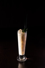 creamy alcohol cocktail with mint leaves on a neutral black background