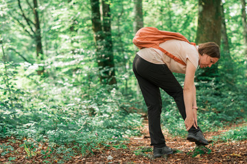 Naklejka na ściany i meble Female hiker with ankle injury in forest