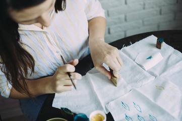 girl master makes stamps on the fabric. handmade