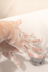 Fototapeta premium Washing hands with soap under the faucet with water. Hygiene concept.