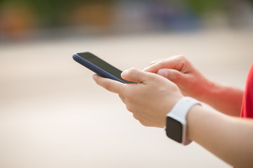 Asian woman using smartphone outdoors