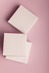 Stack of white cardboard boxes on a pink background with copyspace for your text