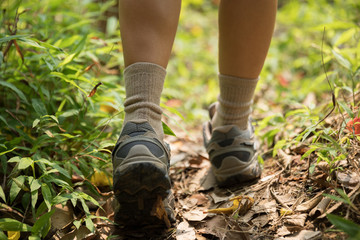 Woman hiker legs walking on trail in spring mountains