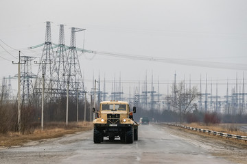 The truck goes along metal supports of power lines near the Chernobyl nuclear power plant in Ukraine. February 2015