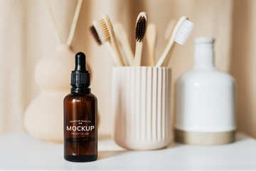 Brown dropper bottle and bamboo toothbrushes still life
