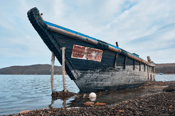 An old shipwreck Abandoned North Korean fishing boat on the sea coast. Low wide angle view