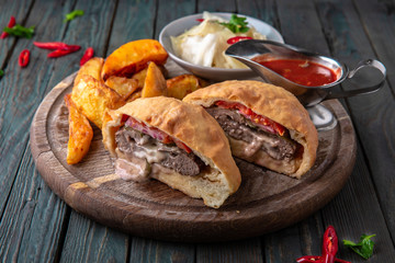 Traditional Georgian food. Meat loaf. Baked meat in pastry with potatoes and pickles.