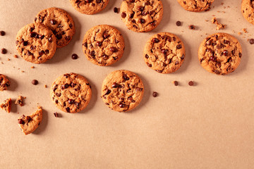 Chocolate chip cookies on a brown background, shot from the top with a place for text