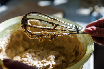 mixing wholemeal homemade vegan bread in plastic bowl