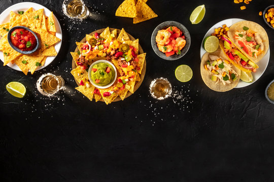 Mexican food, many different dishes, shot from above on a black background with a place for text