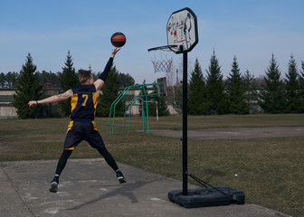 Basketball player in the jump throws the ball into the basket.