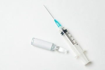 Syringe and ampoule with medicine on white background. Close up. Copy space. Mock up