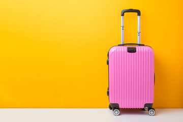 Pink baggage on yellow background, travel concept