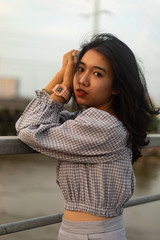 A young beautiful girl poses on an old bridge.