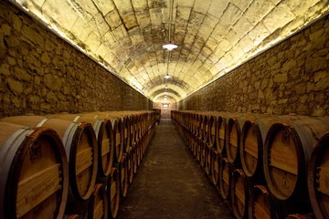 Aged Wine Barrels Neatly Stacked in a Cellar