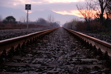 Fototapeta na wymiar Binario arrugginito di una vecchia ferrovia, al tramonto