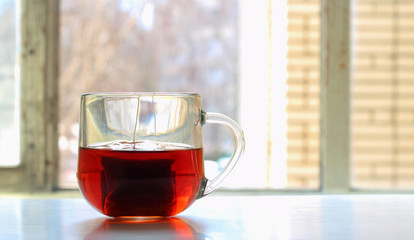 an unfinished Cup of fragrant tea on the table against the background of the window