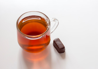 transparent glass Cup with delicious tea and chocolate on a white background