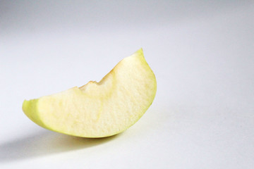 slice a piece of Apple on the left side on a white gray background