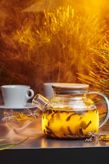 Tea in a transparent teapot. Warm background