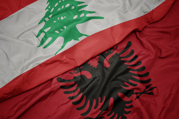 waving colorful flag of albania and national flag of lebanon.