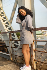 A young beautiful girl poses on an old bridge.