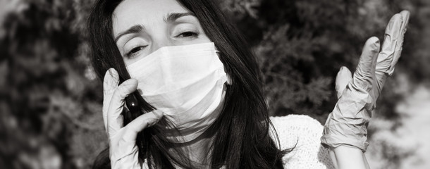 woman in a medical mask with a mobile phone