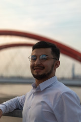 Man poses on an old bridge.