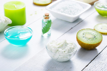 beauty products with kiwi fruit ingredient on white wooden table