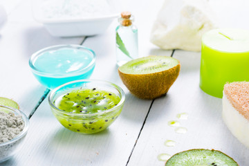 beauty products with kiwi fruit ingredient on white wooden table
