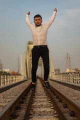 Fototapeta na wymiar Man poses on an old bridge.