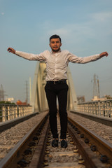 Man poses on an old bridge.