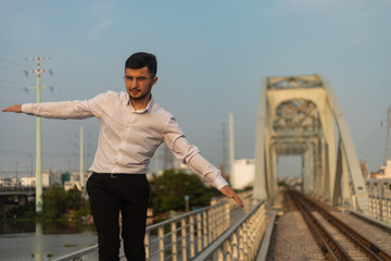 Man poses on an old bridge.